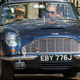 Prince Charles, right, waves as he leaves his official residence Clarence House in London in his vintage Aston Martin with an unidentified driver.